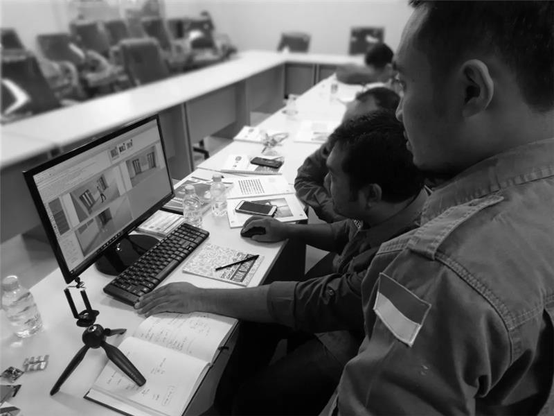 Two men focus intently on a computer screen displaying automeasure